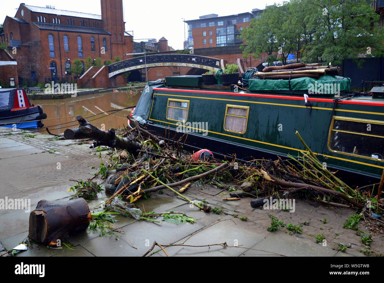 Les débris laissés à côté d'un bateau après le canal à Castlefield, Manchester, UK, a inondé le 28 juillet 2019. De fortes pluies dans le Nord-Ouest a mené à la Met Office émettre plusieurs avertissements d'inondations dans la région. Banque D'Images