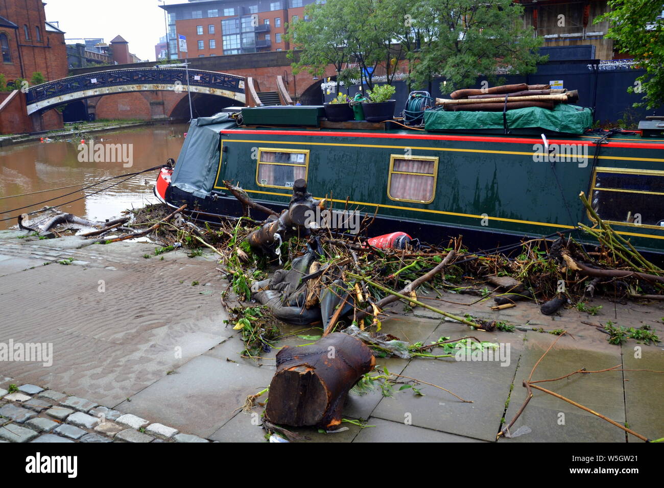 Les débris laissés à côté d'un bateau après le canal à Castlefield, Manchester, UK, a inondé le 28 juillet 2019. De fortes pluies dans le Nord-Ouest a mené à la Met Office émettre plusieurs avertissements d'inondations dans la région. Banque D'Images