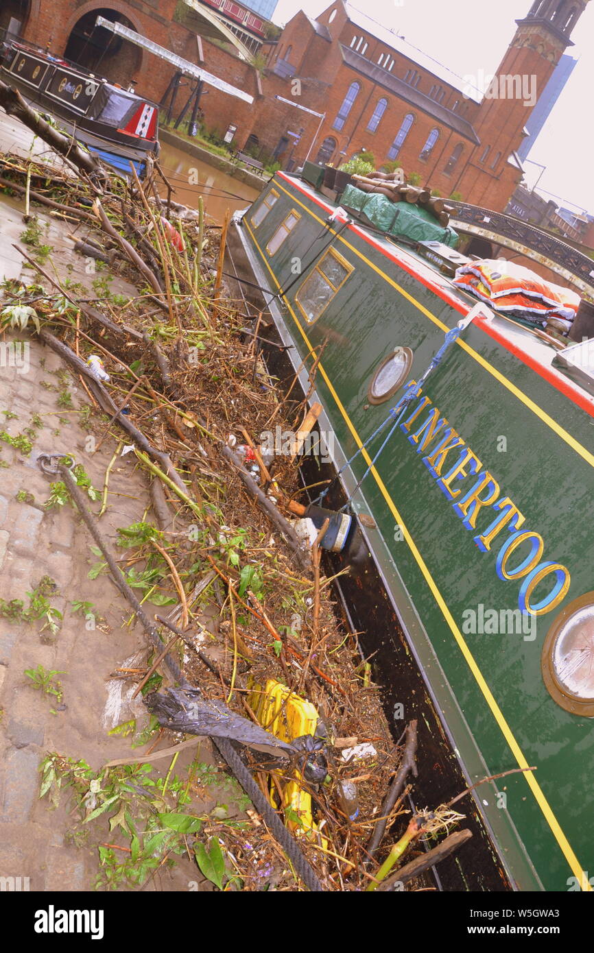 Les débris laissés à côté d'un bateau après le canal à Castlefield, Manchester, UK, a inondé le 28 juillet 2019. De fortes pluies dans le Nord-Ouest a mené à la Met Office émettre plusieurs avertissements d'inondations dans la région. Banque D'Images