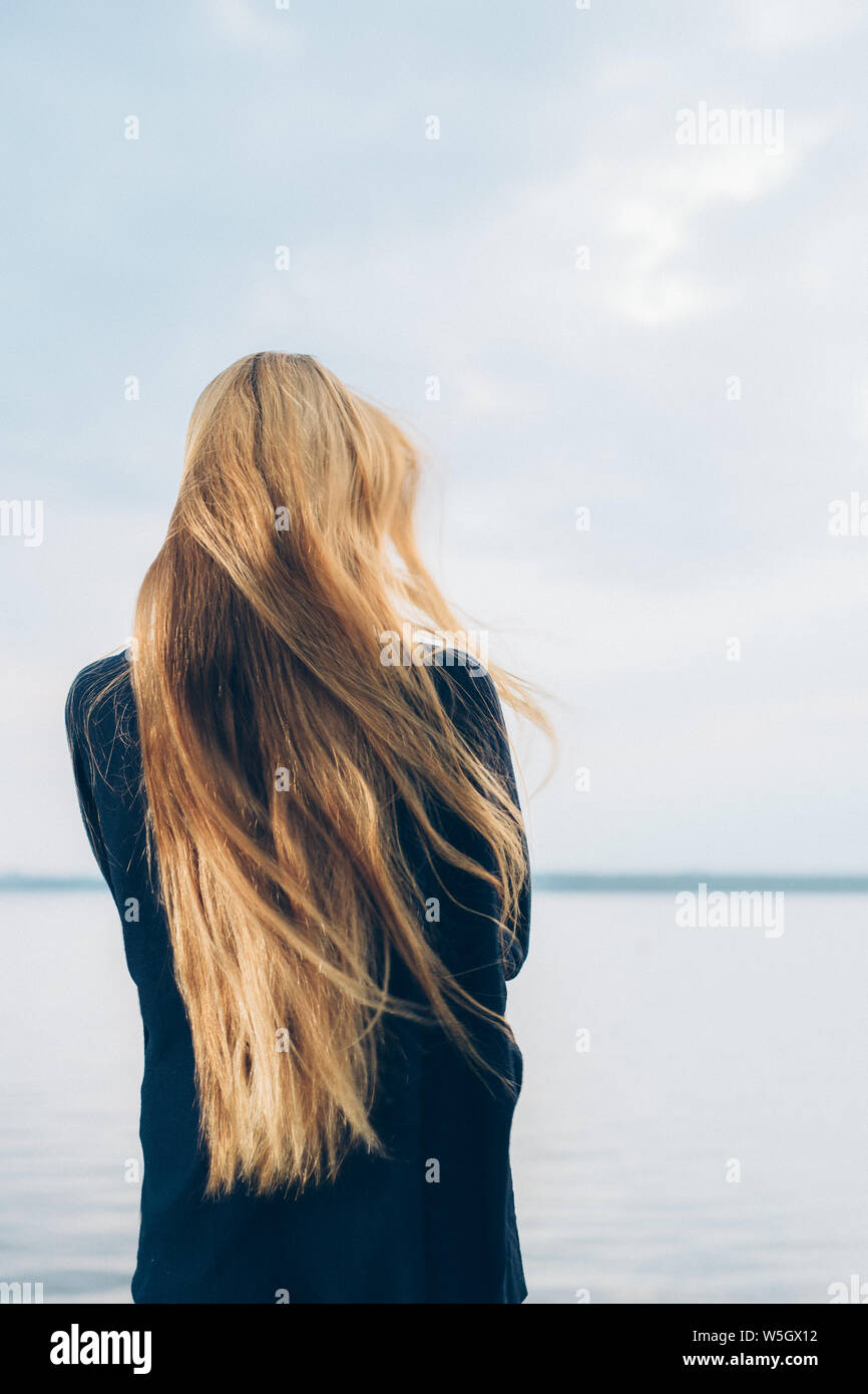 Portrait de femme avec dos à la caméra et permanent à la recherche sur le lac Banque D'Images