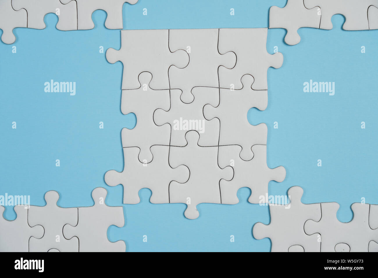 Jigsaw Puzzle pieces manquantes. Concept d'entreprise. Fragment d'un puzzle blanc plié et un tas d'éléments de puzzle non peignées contre l'arrière-plan Banque D'Images