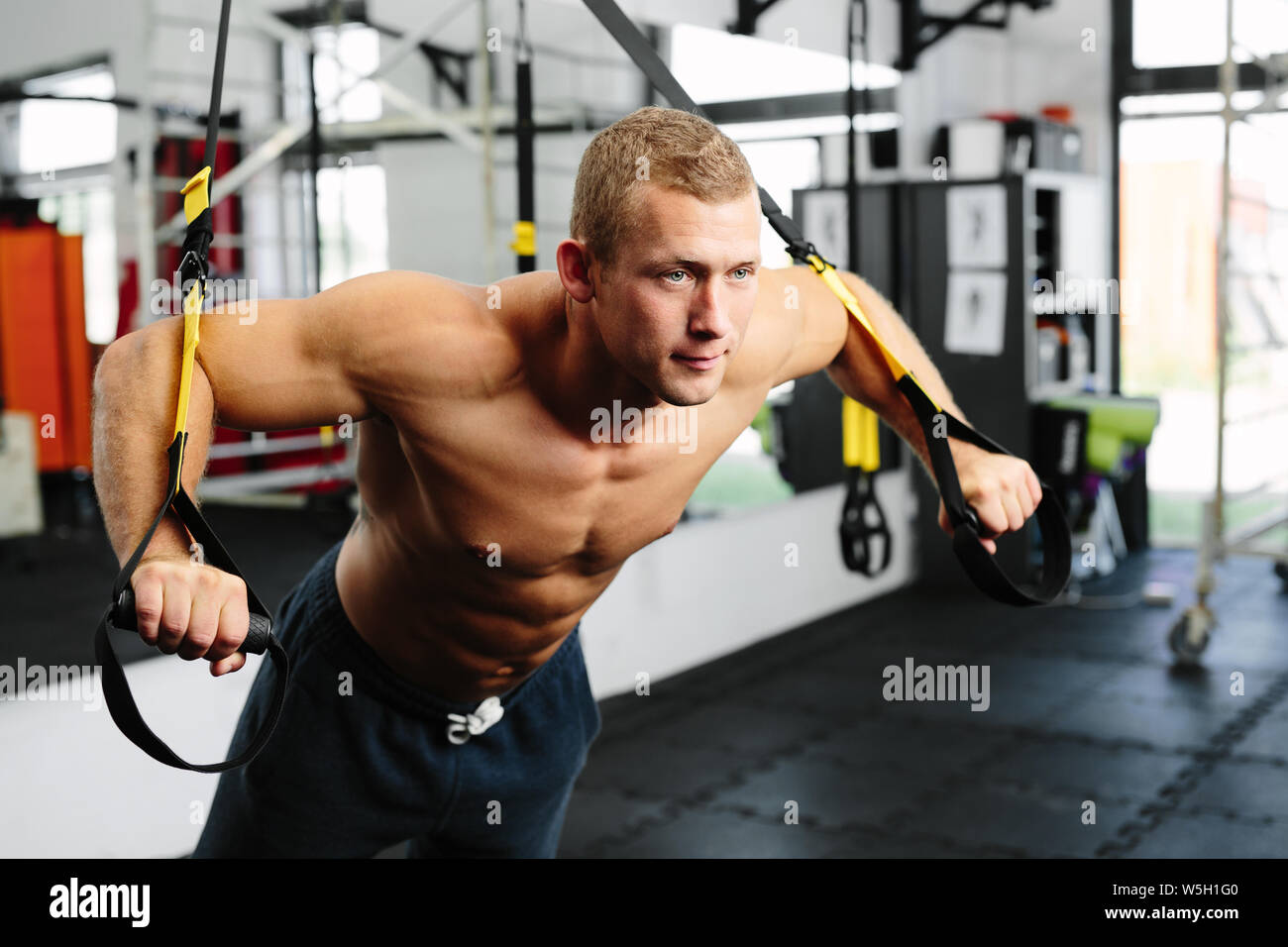 Photo d'un jeune athlète musculaire au cours d'une formation de suspension Banque D'Images