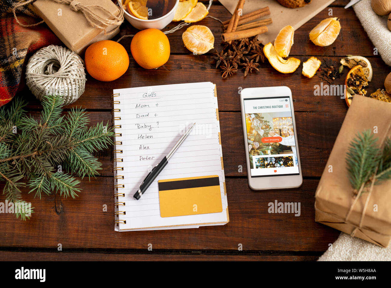 Smartphone avec promo, bloc-notes, penand carte de crédit parmi les trucs sur la table de Noël Banque D'Images