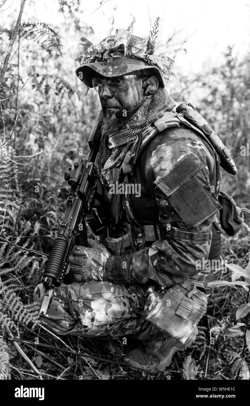 Joueur de jeu militaire Airsoft des uniformes de camouflage avec Armed Assault Rifle. Banque D'Images