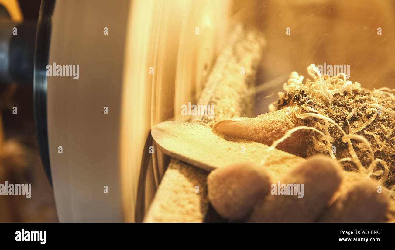 Menuisier bois poignées par banc. Faire de beaux faits main en bois plat. Artisan travaille avec pièce en atelier. La sciure de voler de façon détaillée dans des f Banque D'Images