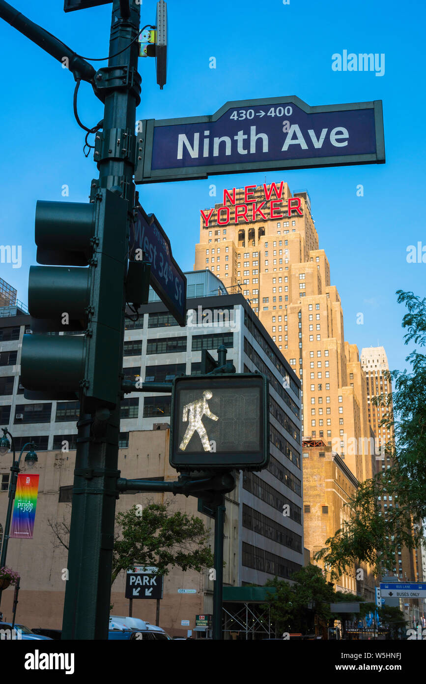 Rue de Manhattan, vue de feux de circulation à l'angle de la 9e Avenue et West 54th Street avec l'emblématique red New Yorker Hotel sign dans la distance, la ville de New York. Banque D'Images