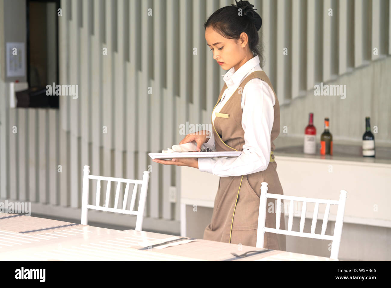 Serveuse Asian expose sur un tableau blanc de couverts. Banque D'Images