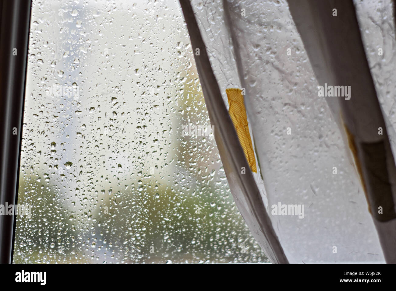 Gouttes de pluie sur les vitres à l'arrière-plan flou jour de pluie à l'extérieur bleu ciel nuage - Image de texture Banque D'Images