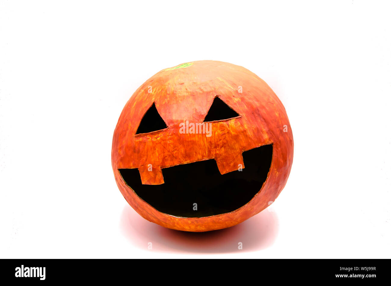Orange citrouille avec la bouche ouverte et yeux triangulaires à partir de papier mâché à Halloween isolé sur fond blanc Banque D'Images
