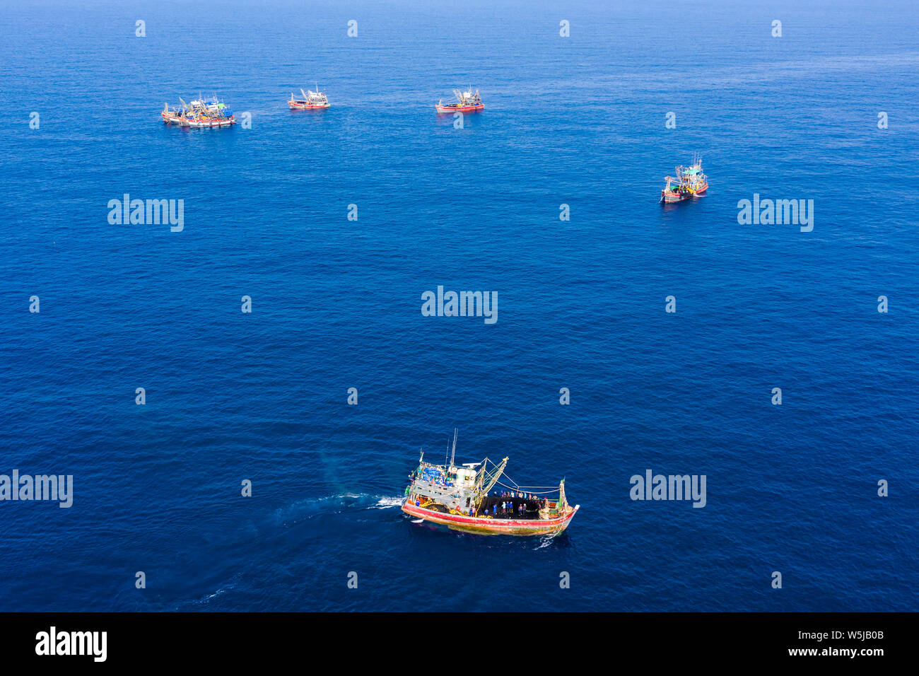 La surpêche - vue aérienne d'une grande flotte de chalutiers de pêche qui travaillent ensemble dans une petite zone de la mer d'Andaman Banque D'Images