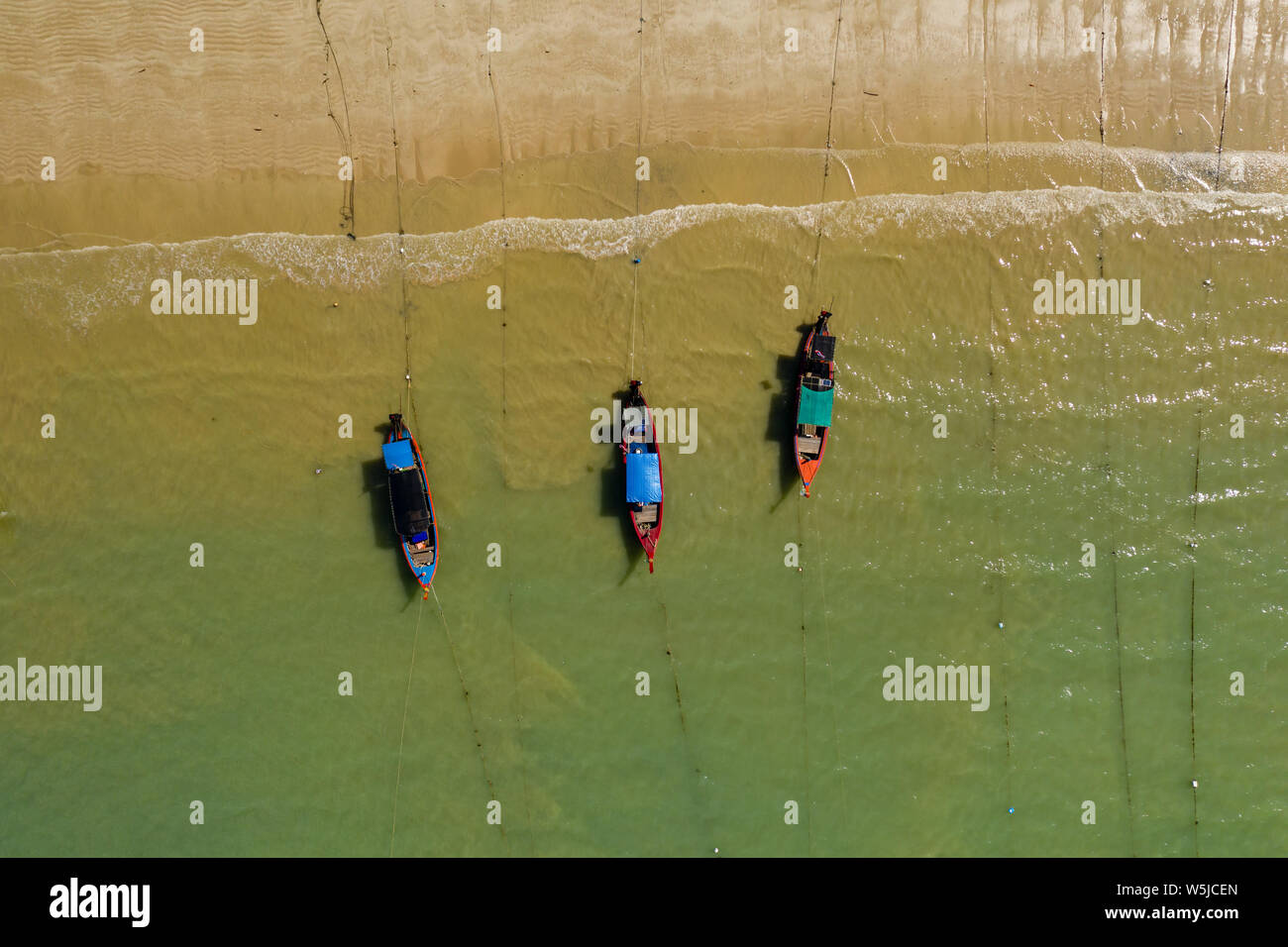 De haut en bas Vue aérienne de Longtail traditionnels en bois colorés bateaux amarrés au large d'une plage tropicale de sable Banque D'Images