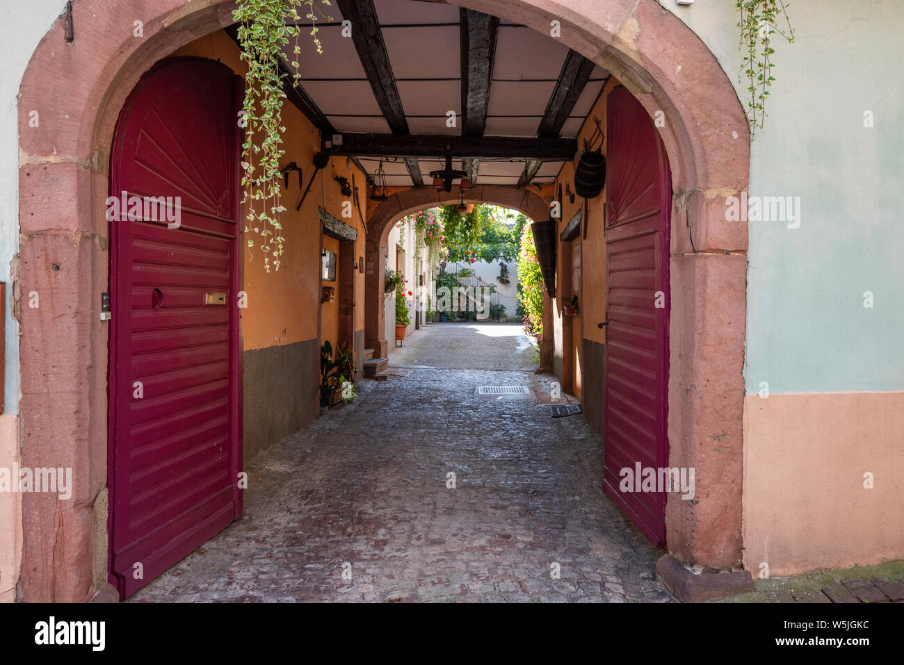 Vue d'une cour intérieure avec porte en bois, village viticole, Ammerschwihr, Alsace, France, architecture typique de l'Alsace Banque D'Images