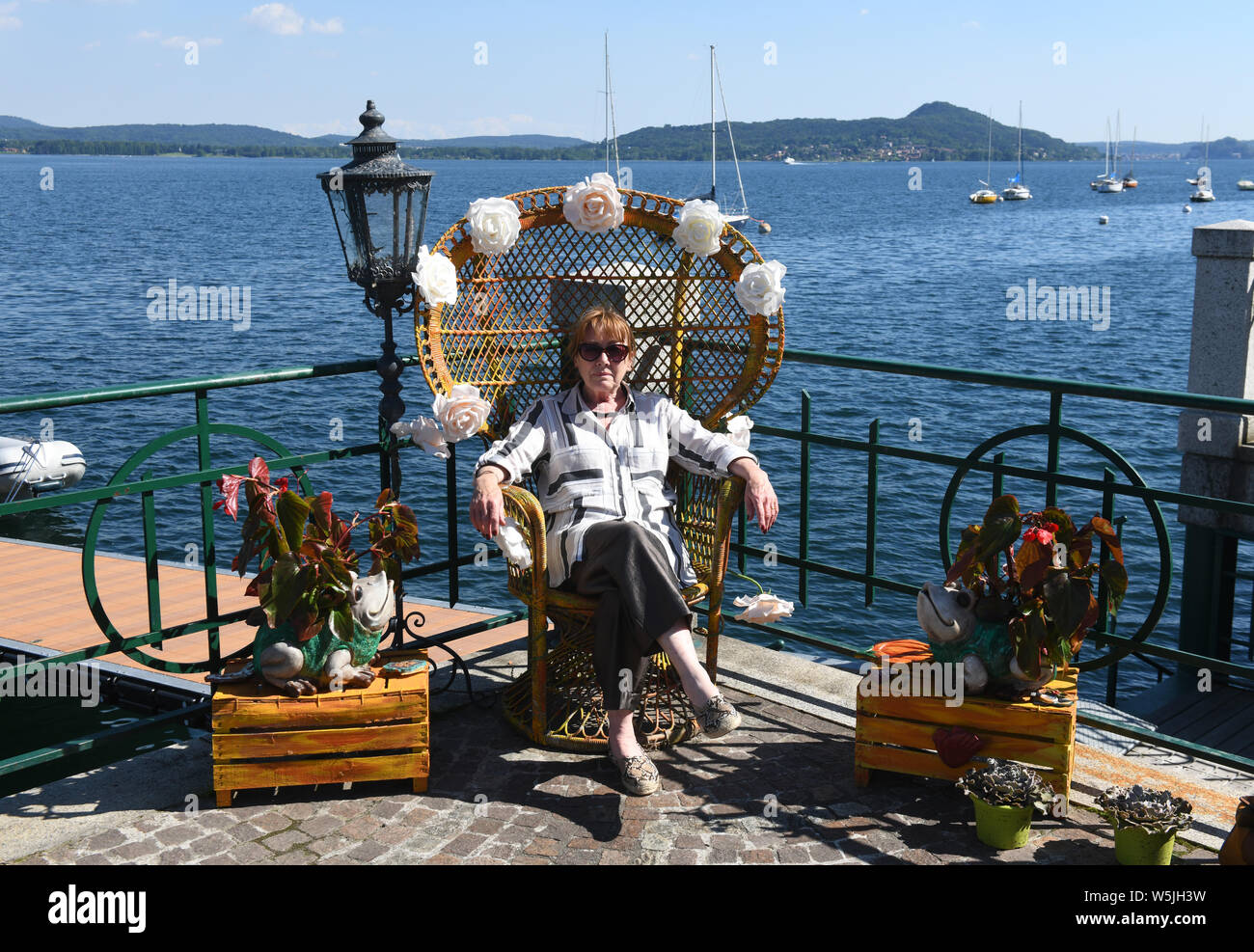 Touriste assis dans affichage floral présidence à Belgirate, Lake Maggiore, Piémont, Italie Banque D'Images
