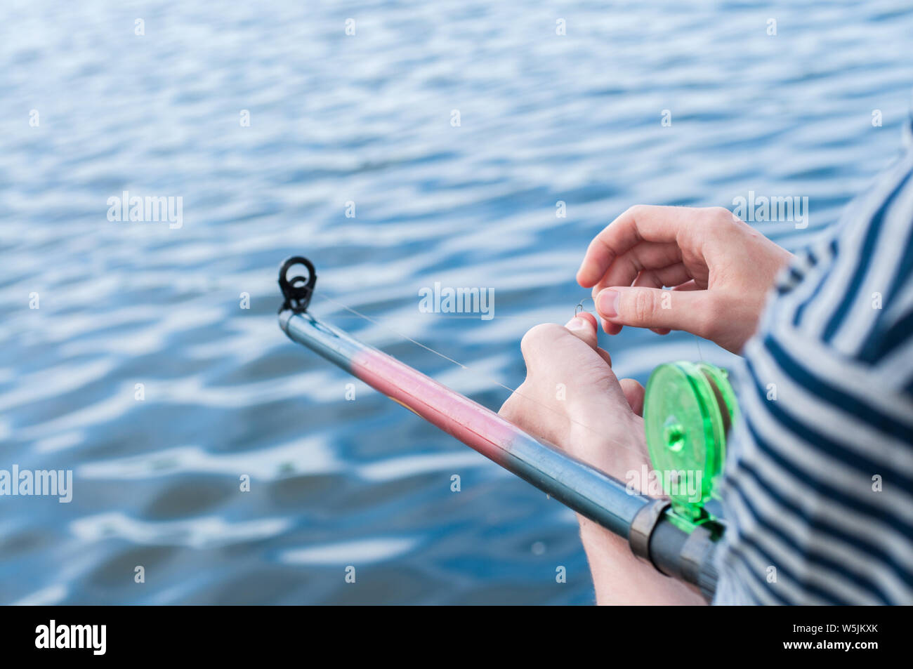 L'homme à l'effilochage et noués emmêlées ligne de pêche. La résolution de problèmes. Banque D'Images