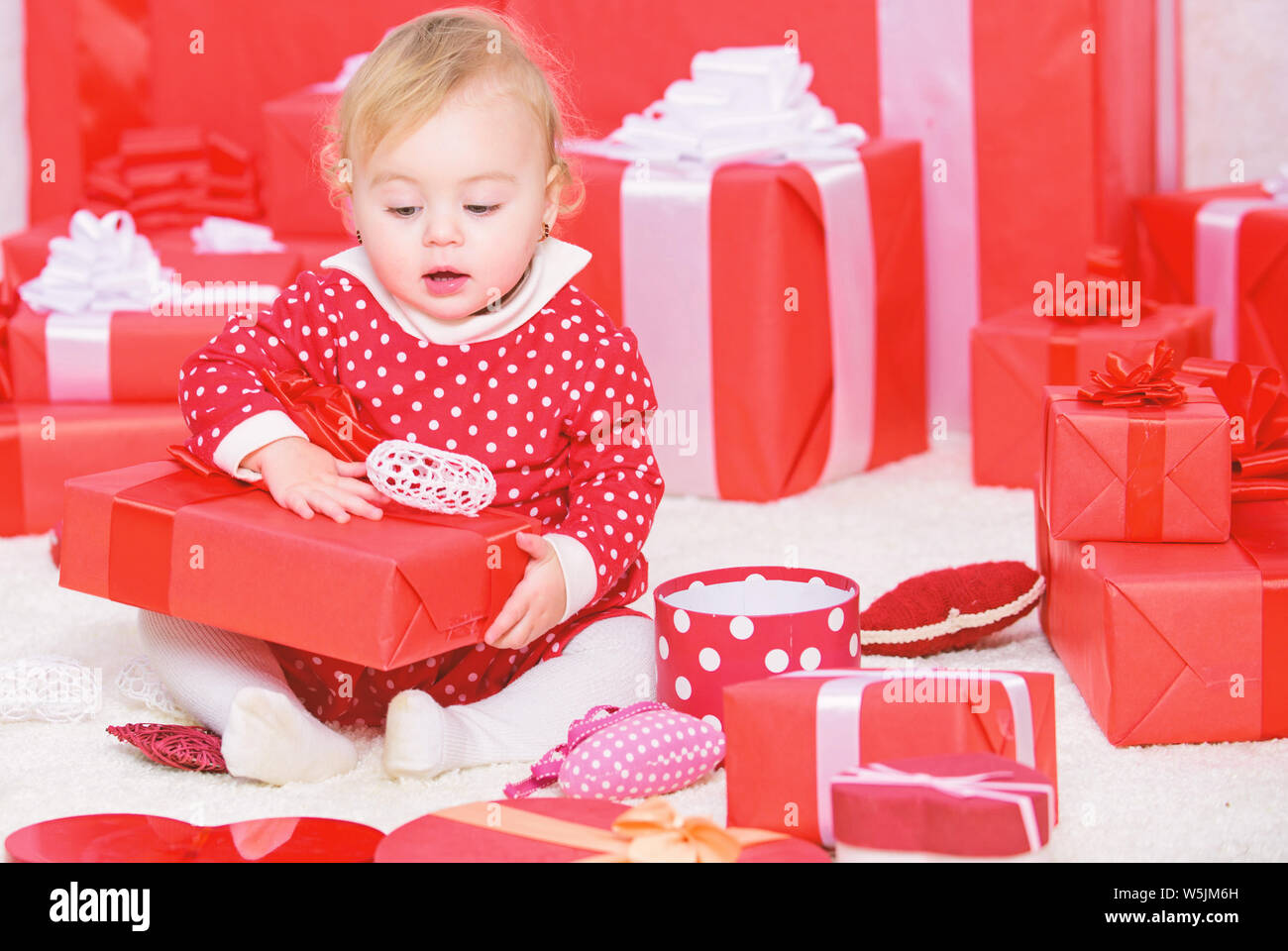 Premier Noël de bébé, au cours de la vie, une fois l'événement. Little baby girl jouer près de tas de boîtes cadeaux. Cadeaux pour enfant premier noël. Première fête de Noël. Partager la joie de Noël avec bébé première famille. Banque D'Images