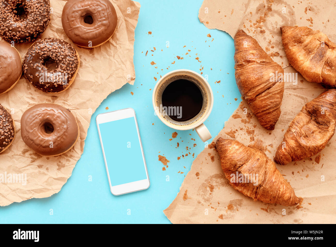 Croissants et café donuts au chocolat pour le petit-déjeuner avec smart phone, la maquette vue de dessus de table snack sur doux Banque D'Images