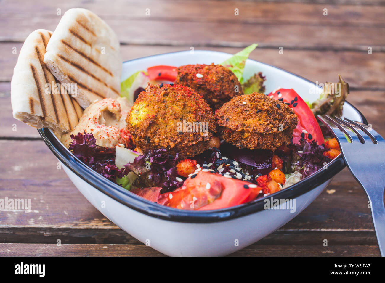 L'alimentation de rue israélienne. Salade Falafel d'hummus, de betteraves et de légumes dans un bol dans un restaurant. Banque D'Images