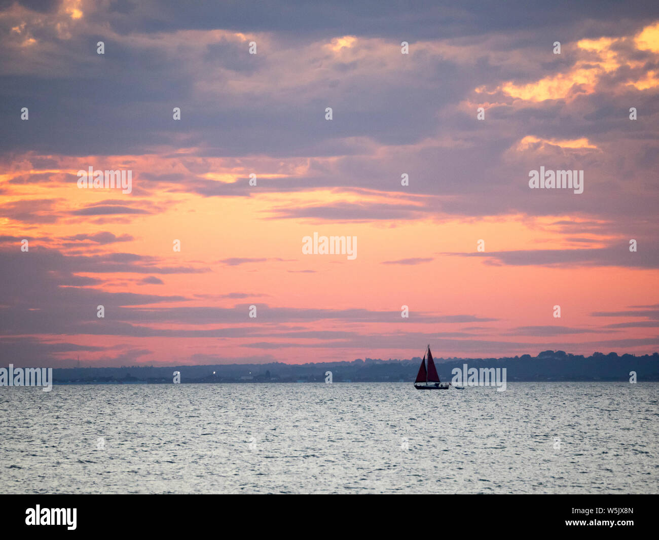 Sheerness, Kent, UK. 29 juillet, 2019. Météo France : un petit voilier renvoie au coucher du soleil à Sheerness, Kent. Credit : James Bell/Alamy Live News Banque D'Images