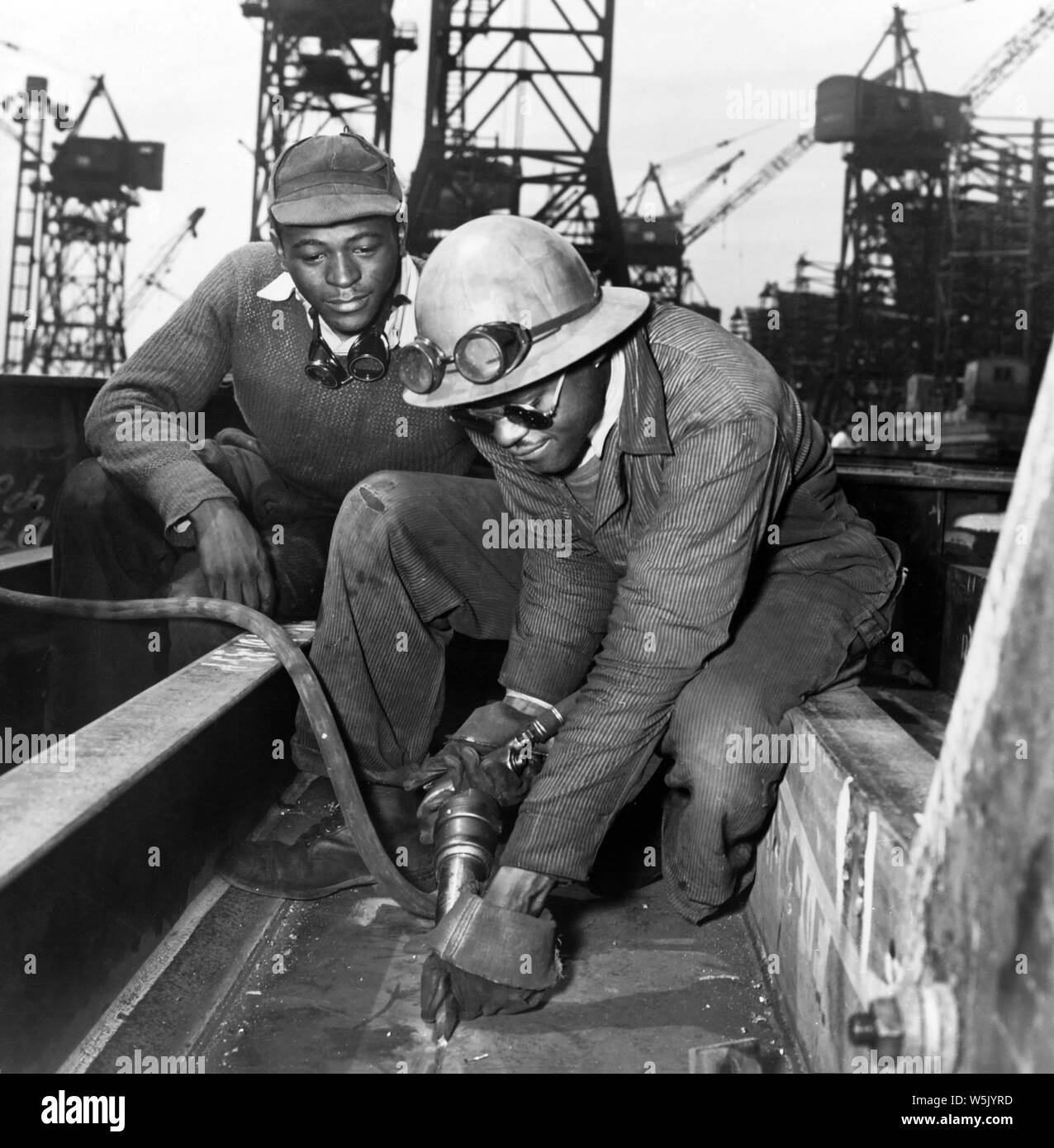 Un broyeur éliminant l'excès de métal d'un joint soudé durant la construction de la Liberty Ship Frederick Douglass, Bethlehem-Fairfield Chantiers navals, Baltimore, Maryland, USA, Roger Smith, Bureau américain de la guerre de l'information, mai 1943 Banque D'Images