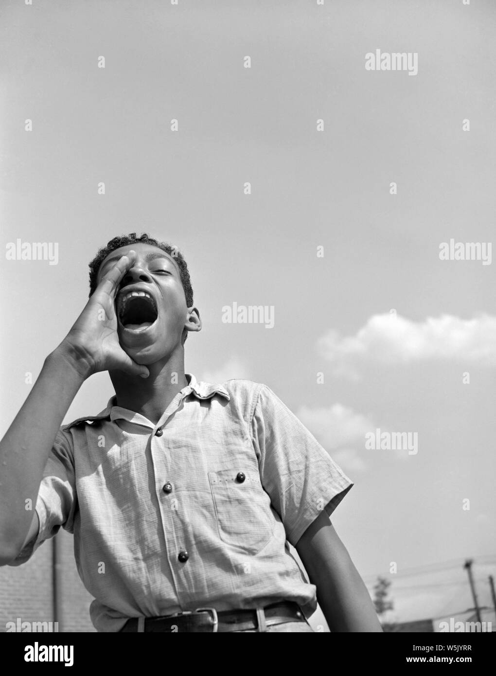 Teen Garçon crier à des amis à l'aire de jeux, Projet de logement de Frederick Douglass, Quartier Anacostia, Washington DC, USA, photo de Gordon Parks, Juin 1942 Banque D'Images
