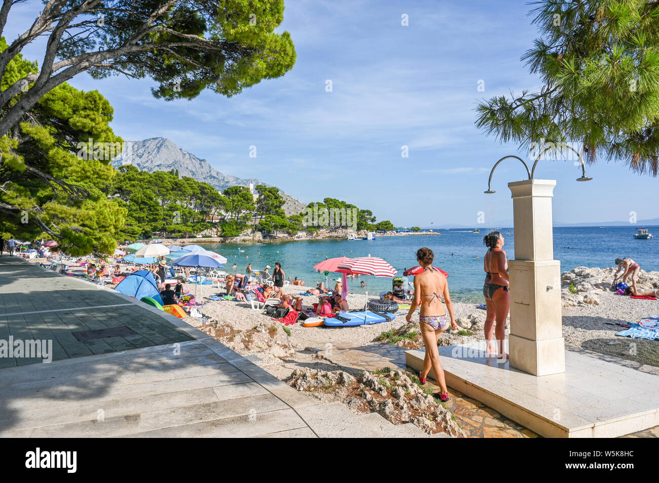 Les touristes profiter de la plage de Brela. La riviera de Makarska en Croatie est célèbre pour ses belles plages de galets et de l'eau claire comme du cristal. Banque D'Images