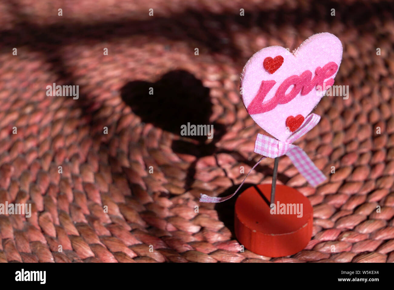 Love concept : forme de Cœur sur un support à mot amour et une ombre qui améliore la forme de coeur. Banque D'Images