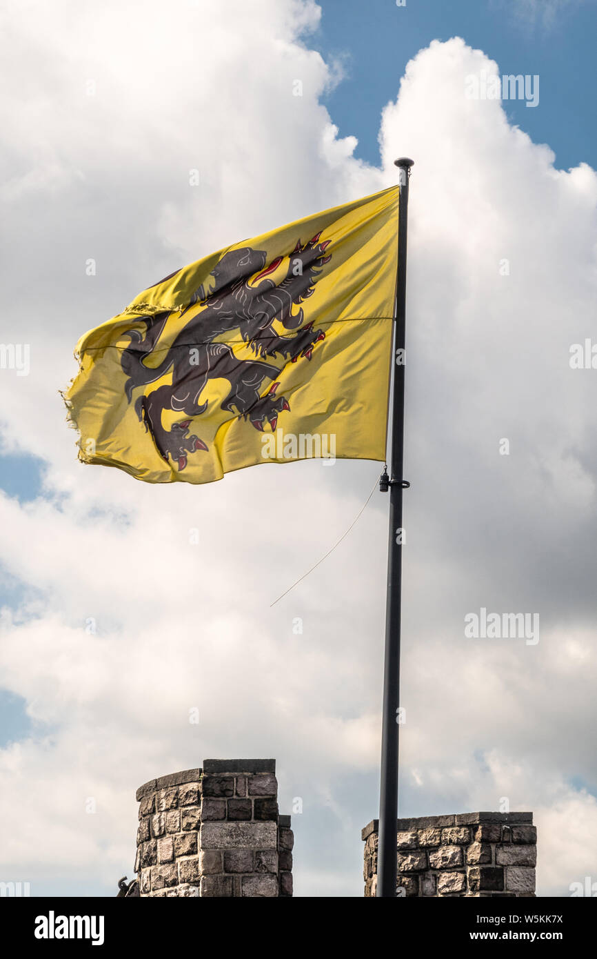 Gand, Flandre orientale, Belgique - 21 juin 2019 : noir-jaune-rouge d'un drapeau de la Flandre sur l'état haut de tour du château blanc contre le bleu avec cloudscape Banque D'Images