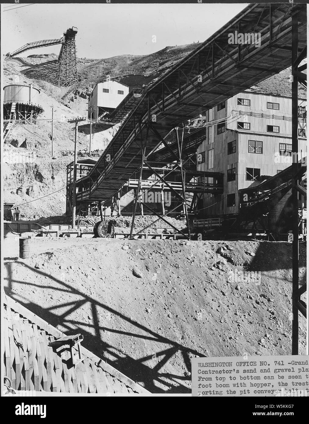 L'entrepreneur de l'usine de sable et de gravier. De haut en bas on peut voir la flèche de 200 pieds avec hopper, le chevalet soutenant la fosse convoyeur à courroie, l'approvisionnement en eau le réservoir, l'aplatisseur chambre à l'aide de tapis, le tapis de gravier pour le 6 x 3 in total, une extrémité de l'écran chambre et dans le coin inférieur gauche du tunnel en bois. ; la portée et contenu : la photographie de deux volumes d'une série d'albums de photos documentant la construction du barrage de Grand Coulee et travaux connexes sur le bassin du Columbia Projet. Banque D'Images