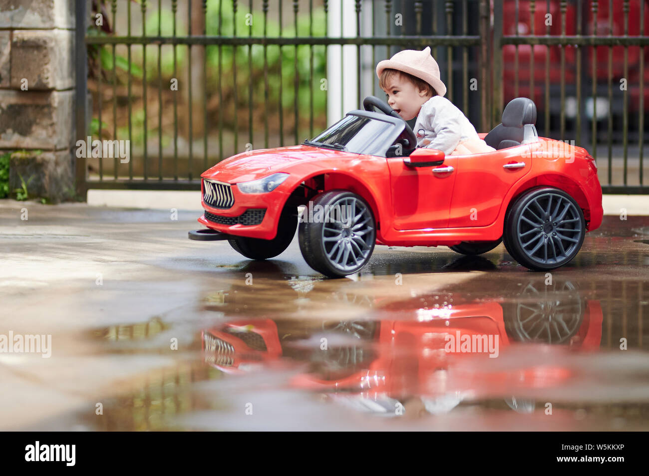 Petite fille bébé jouet voiture voiture dehors dans l'arrière-plan flou park Banque D'Images