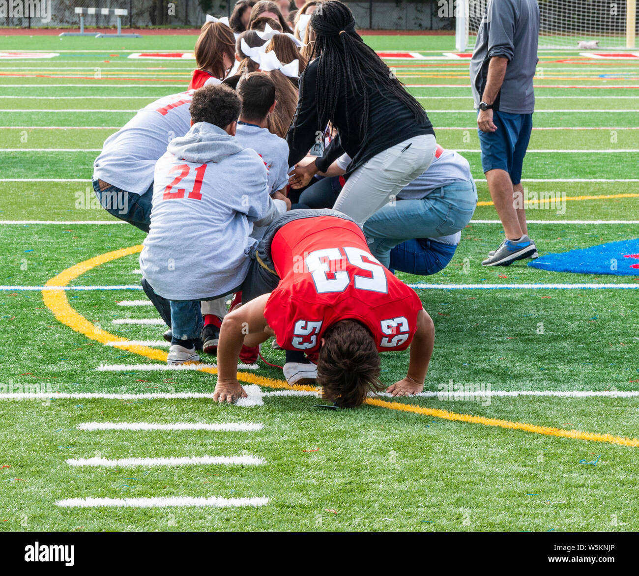 High school kids jouer remorqueur de la guerre sur un champ de gazon vert. Banque D'Images