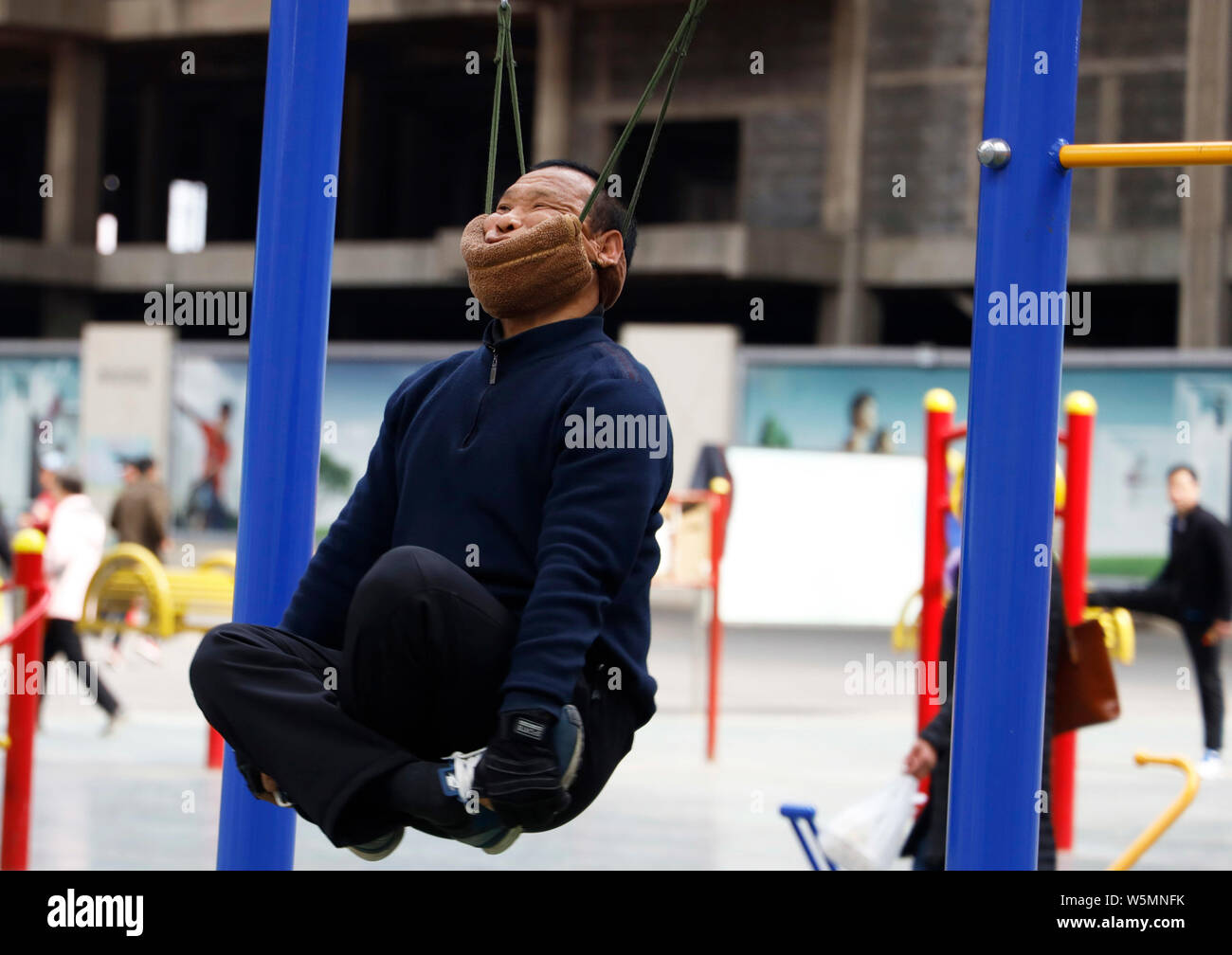 57-year-old Chinese man bien Rongchun exercices avec un engin de traction cervicale périphérique relié à une barre en haut d'un complexe sportif à Shenyang city Banque D'Images
