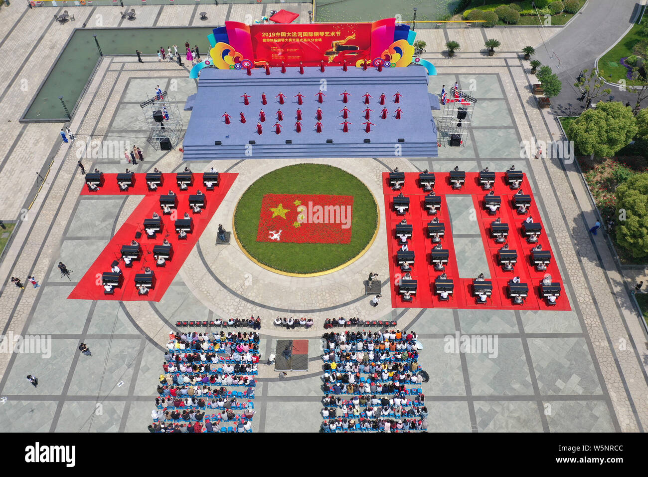 Les participants jouent du piano formant la forme de 70 pour célébrer 70e anniversaire de fondation de la Chine au cours de la compétition à la communication University Banque D'Images