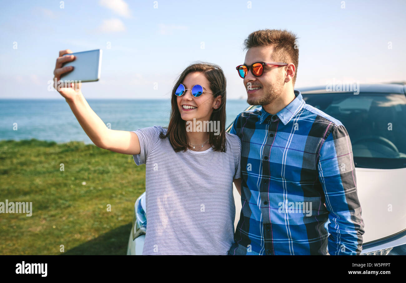 Jeune couple faisant un sur la voiture selfies Banque D'Images