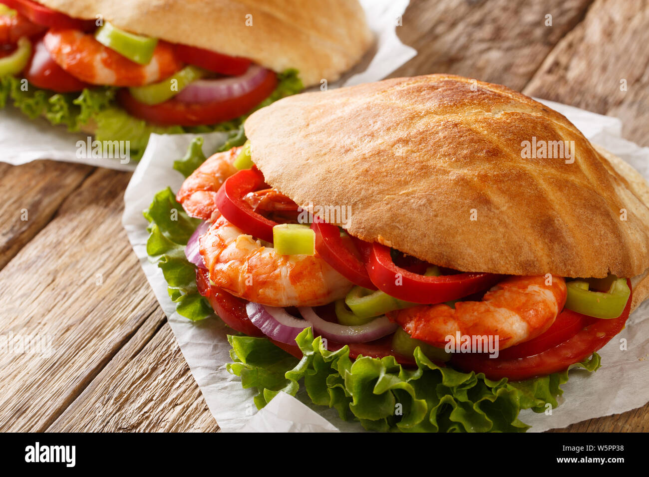 Pita frais avec langoustines, légumes close-up sur le parchemin sur la table horizontale. Banque D'Images