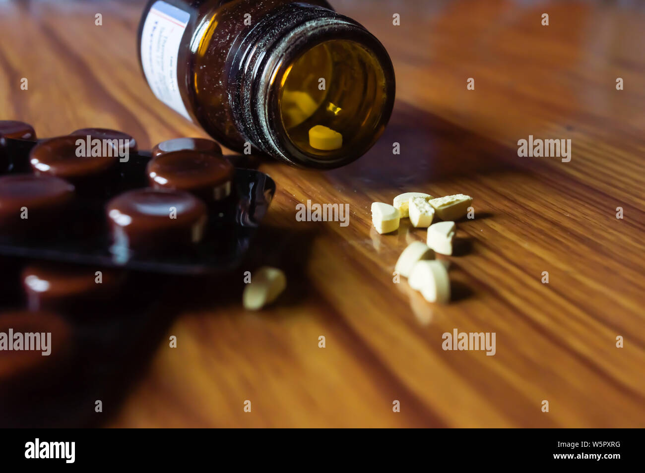 Fermer Ouvrir le flacon en verre transparent avec la médecine pilules ou de comprimés sous blister sur fond de table en bois. Le concept de la santé et guérison de la pharmacie. Selec Banque D'Images