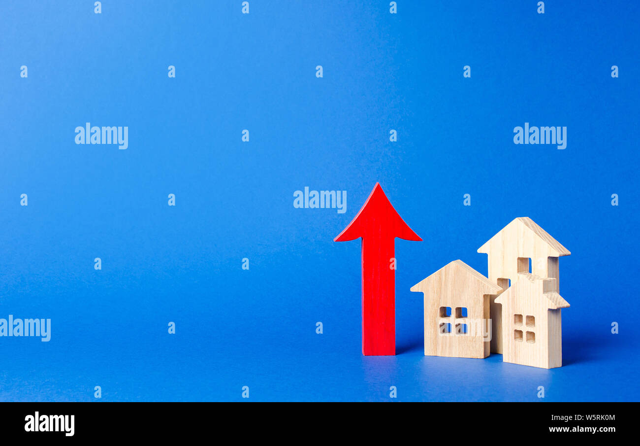 Trois maisons en bois rouge et flèche vers le haut. Des taux élevés de construction, forte liquidité. L'offre et de la demande. Les prix pour le logement, l'entretien des bâtiments. o limite Banque D'Images