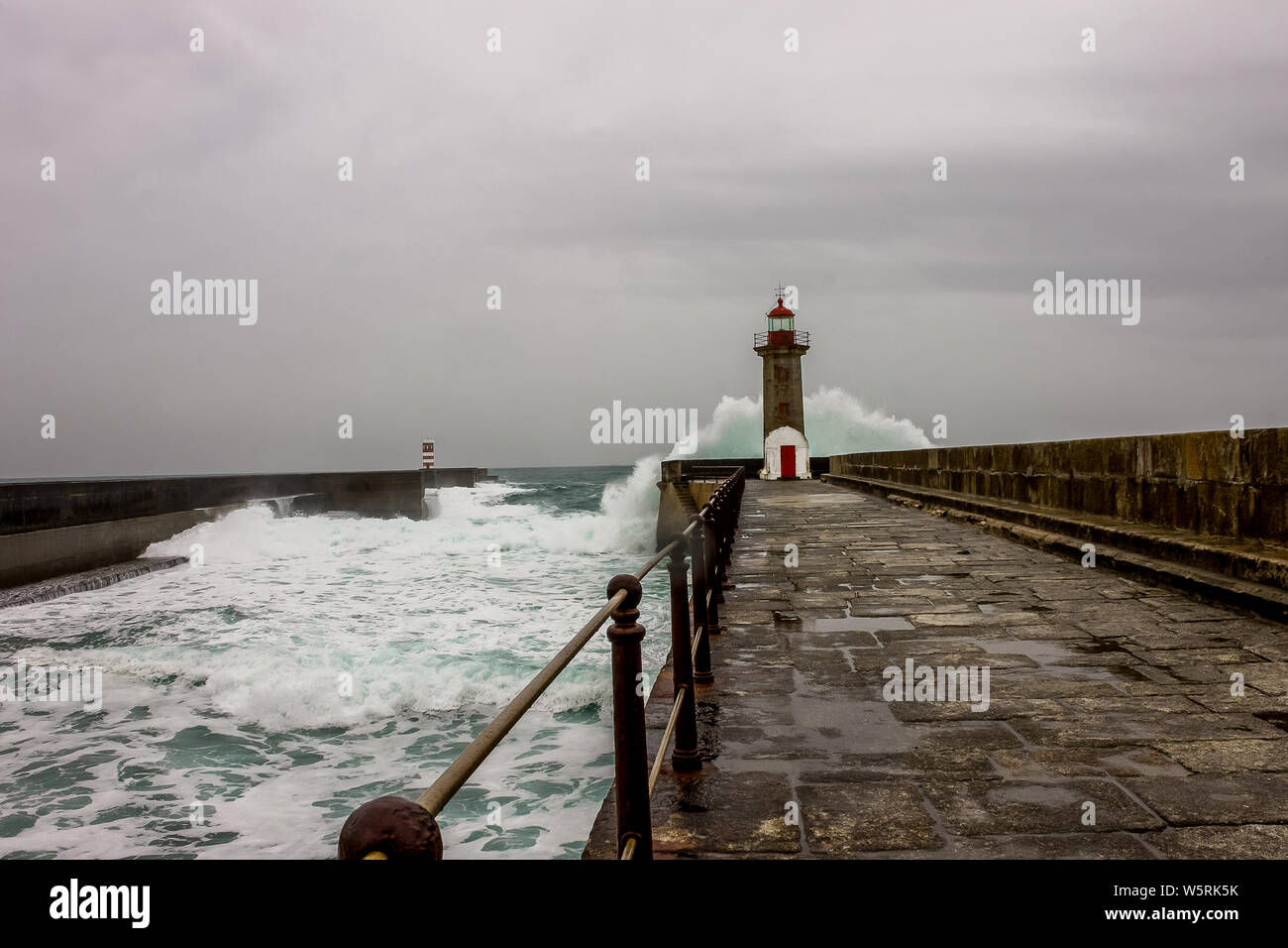 Vagues de la mer se briser contre le phare de Porto, sur les jours pluvieux et venteux. Banque D'Images