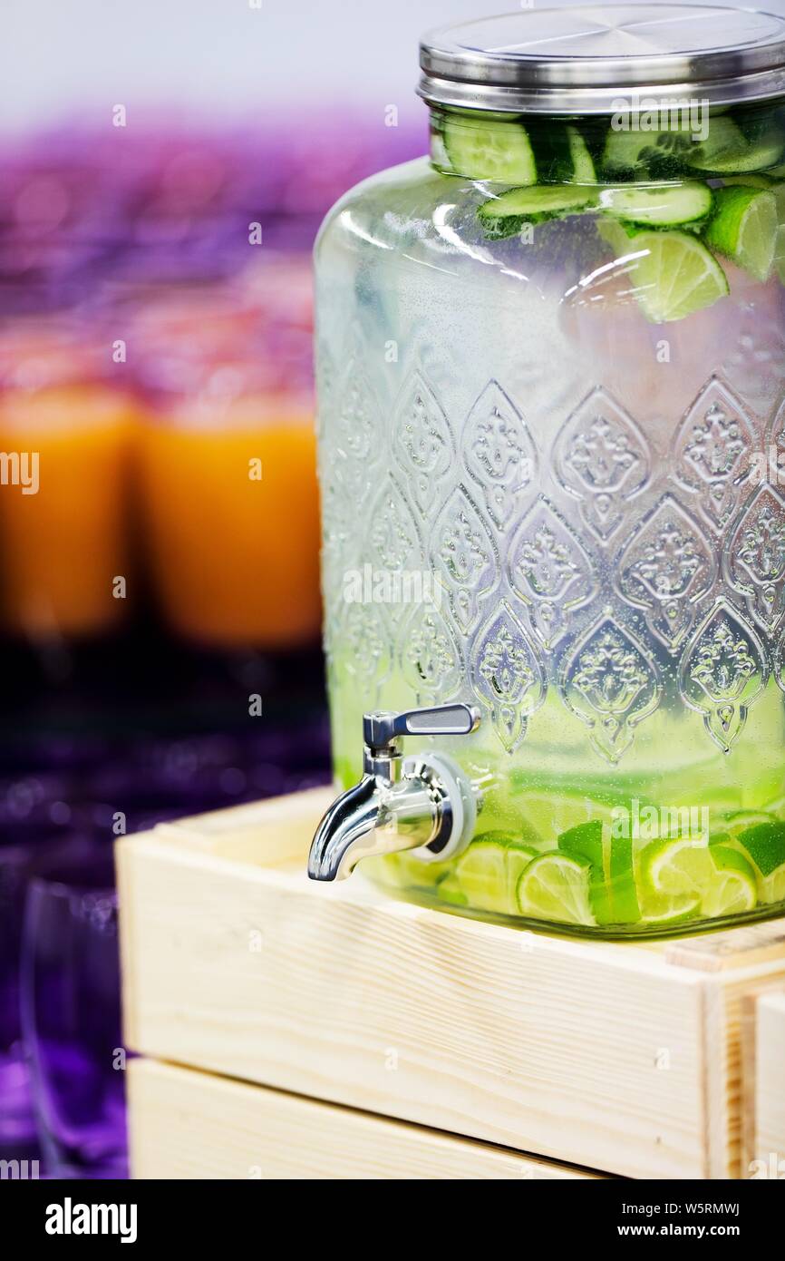 Boisson de fruits et légumes en gros distributeur de boissons en verre,  l'eau avec morceau de concombres et les limes en verre avec robinet de  réservoir Photo Stock - Alamy