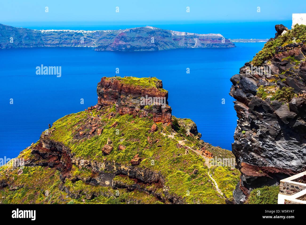 Santorin, Grèce panorama avec Skaros rock, big en pierre volcanique et la mer, la caldeira et le volcan en arrière-plan l'île de fleurs Banque D'Images
