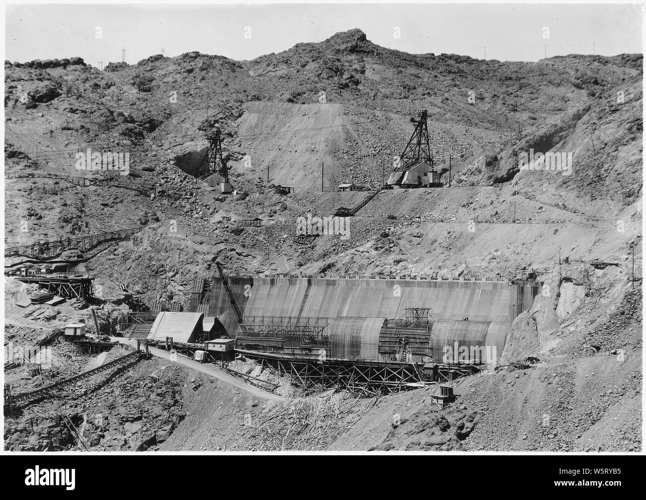 Nevada déversoir et d'un terrain adjacent comme vu de l'Arizona jante de Black Canyon. Tours de tête pour six Companies, Inc., remontées mécaniques nos 5 et 6 vu sur au-dessus de la structure du déversoir. En aval est à gauche sur la photo. ; Portée et contenu : la photographie de deux volumes d'une série d'albums de photos documentant la construction de barrage Hoover, Boulder City, Nevada. Banque D'Images