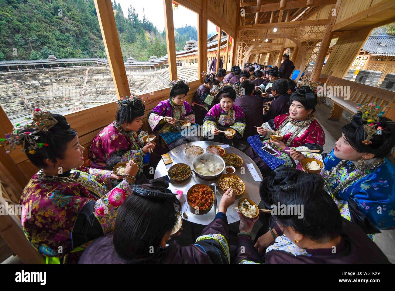 Les Chinois du groupe ethnique Dong habillés en vêtements traditionnels, décorés en argent et headwears savourer un repas traditionnel au cours de l'Dongnian festiva Banque D'Images