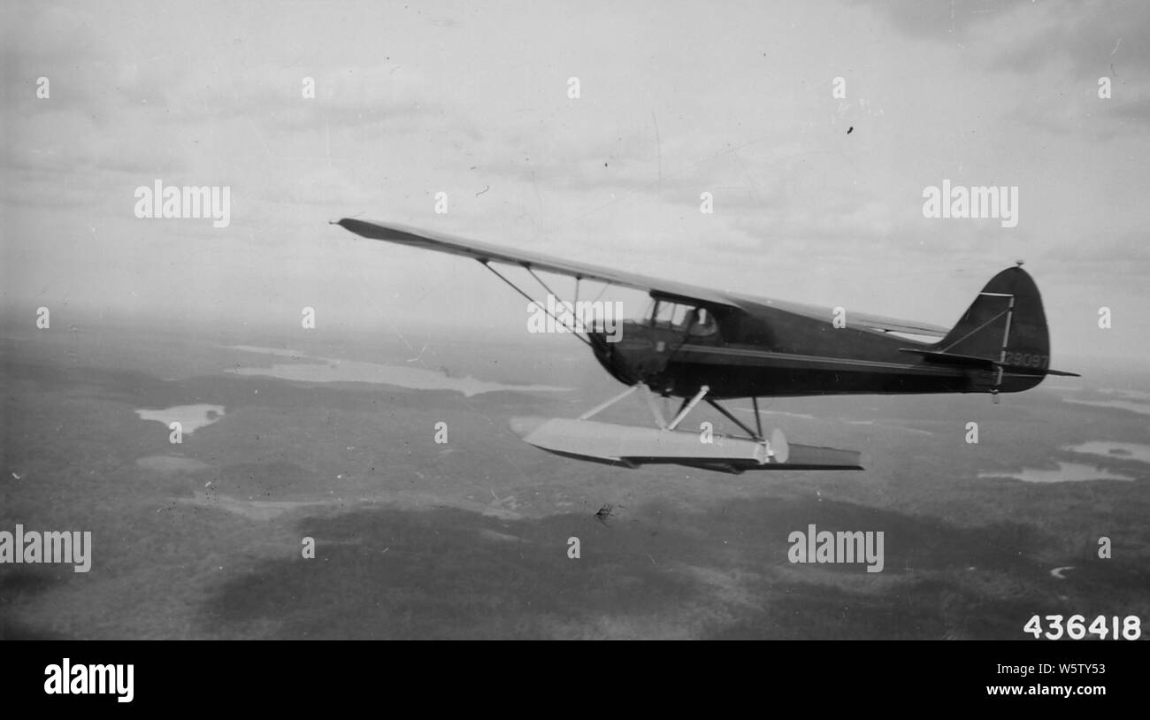 Photographie de Piper Cub avion utilisé dans la détection d'incendie ; la portée et contenu : la légende originale : Piper Cub avion utilisé dans la détection d'incendie, de hauteur au-dessus du lac Supérieur de la région. Banque D'Images