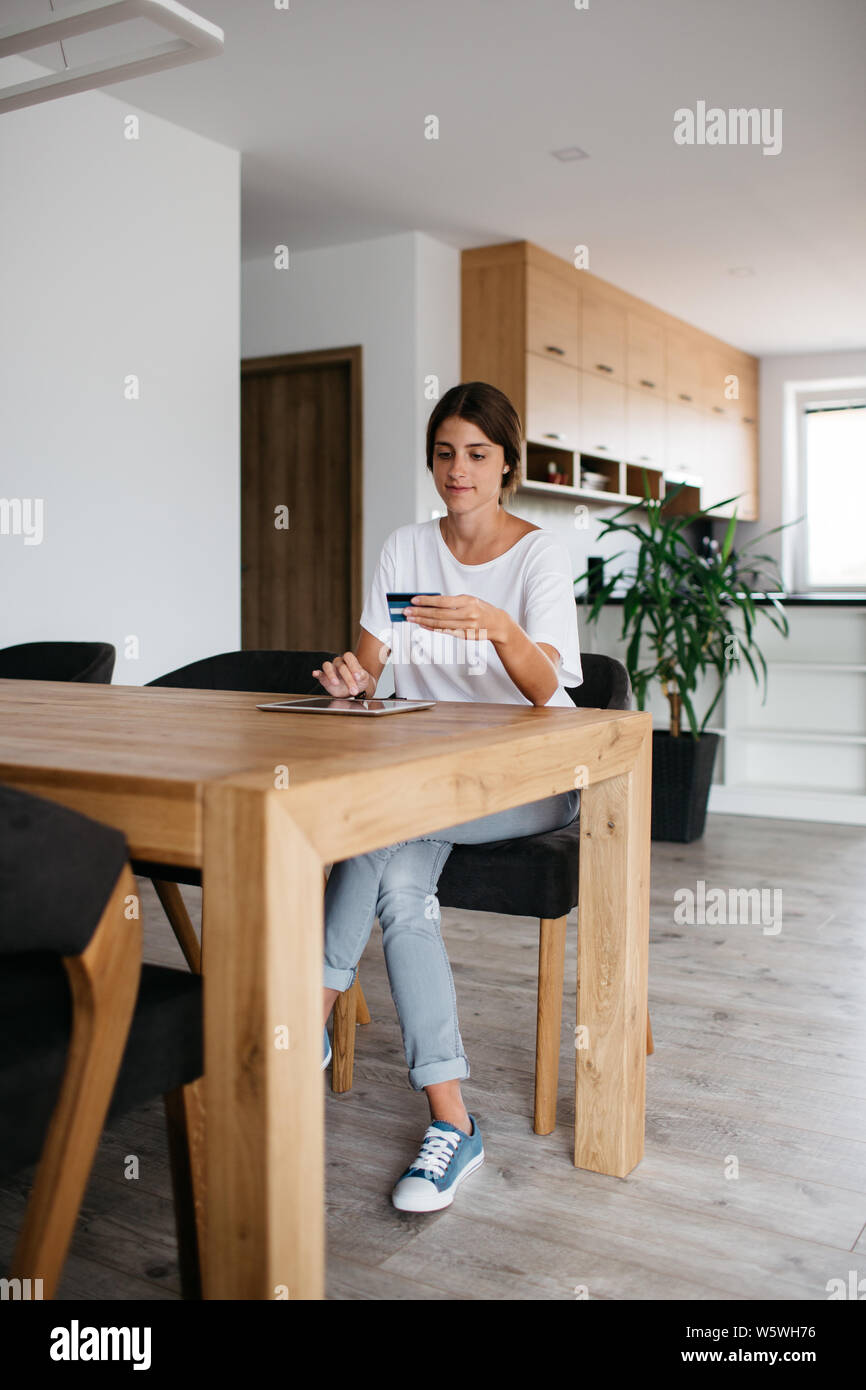 Woman shopping online à la maison. Young woman holding credit card à l'aide d'internet pour effectuer des paiements. Banque D'Images