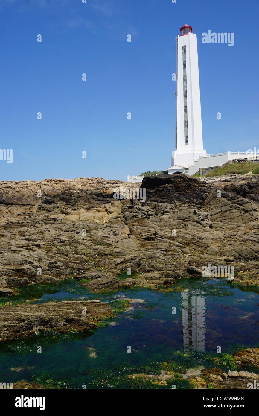 La réflexion de miroir d'un phare blanc dans une flaque de mer sur la côte  rocheuse Photo Stock - Alamy