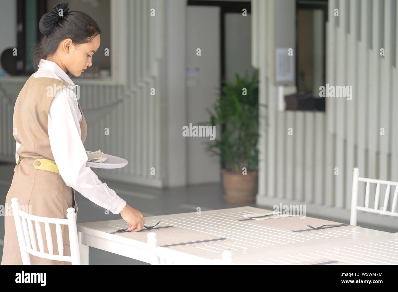 Serveuse Asian expose sur un tableau blanc de couverts. Banque D'Images