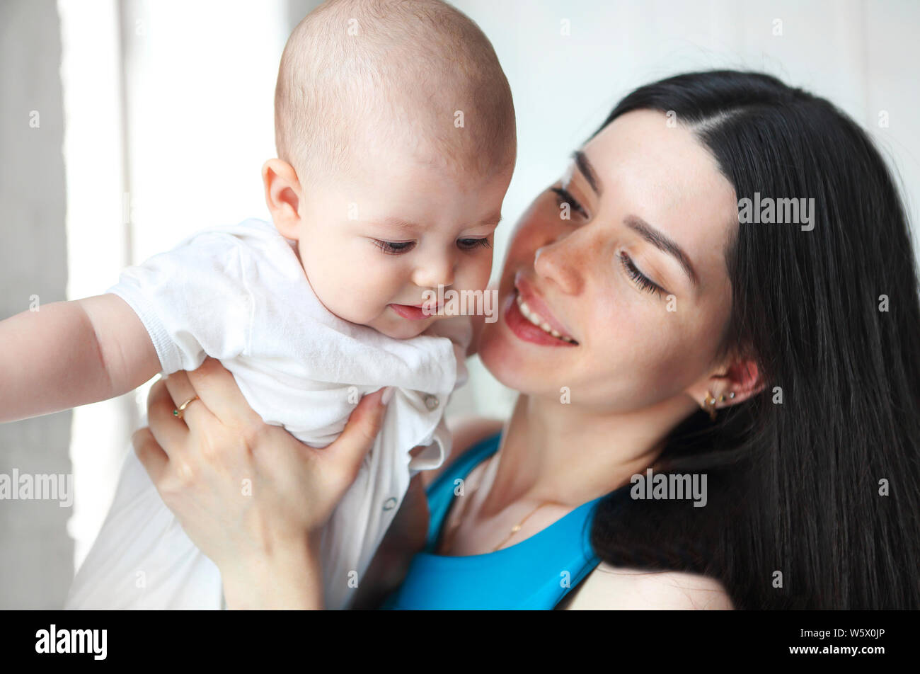 Jeune belle mère holding sweet baby boy sur ses mains Banque D'Images