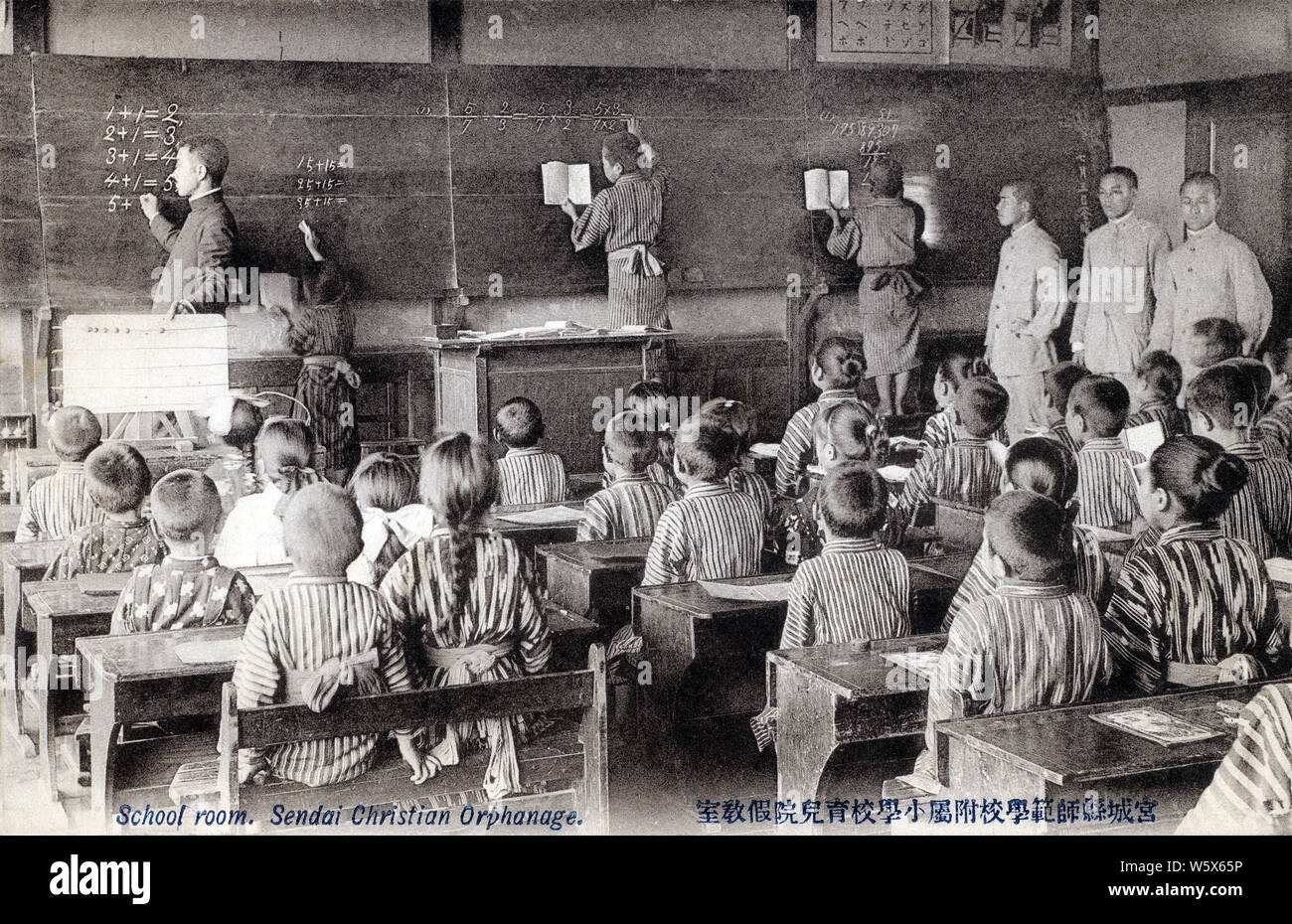 [ 1900 - Japon salle de classe dans un orphelinat chrétien ] - japonais de l'école élémentaire l'étude de l'arithmétique dans une salle de classe de l'orphelinat Chrétien de Sendai (仙台基督教育児院) à Sendai, préfecture de Miyagi. L'orphelinat a été créé en réponse à la famine de 1905 Meiji (38). 20e siècle vintage carte postale. Banque D'Images