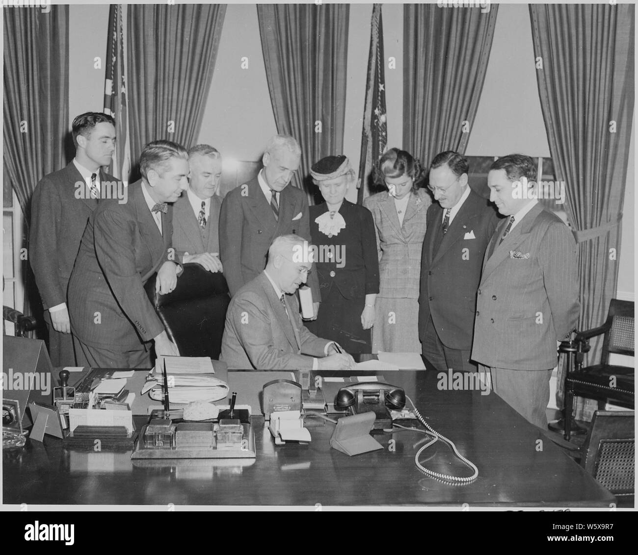 Le Président Truman dans le bureau ovale avec les membres de la Conférence nationale sur la prévention et le contrôle de la délinquance juvénile. Debout, de G à D : Sargent Shriver, Tom Clark, Oscar Ewing, Howland Shaw, Katherine Lenroot, Eunice Kennedy, Frank Weil, et John Andrews. Banque D'Images