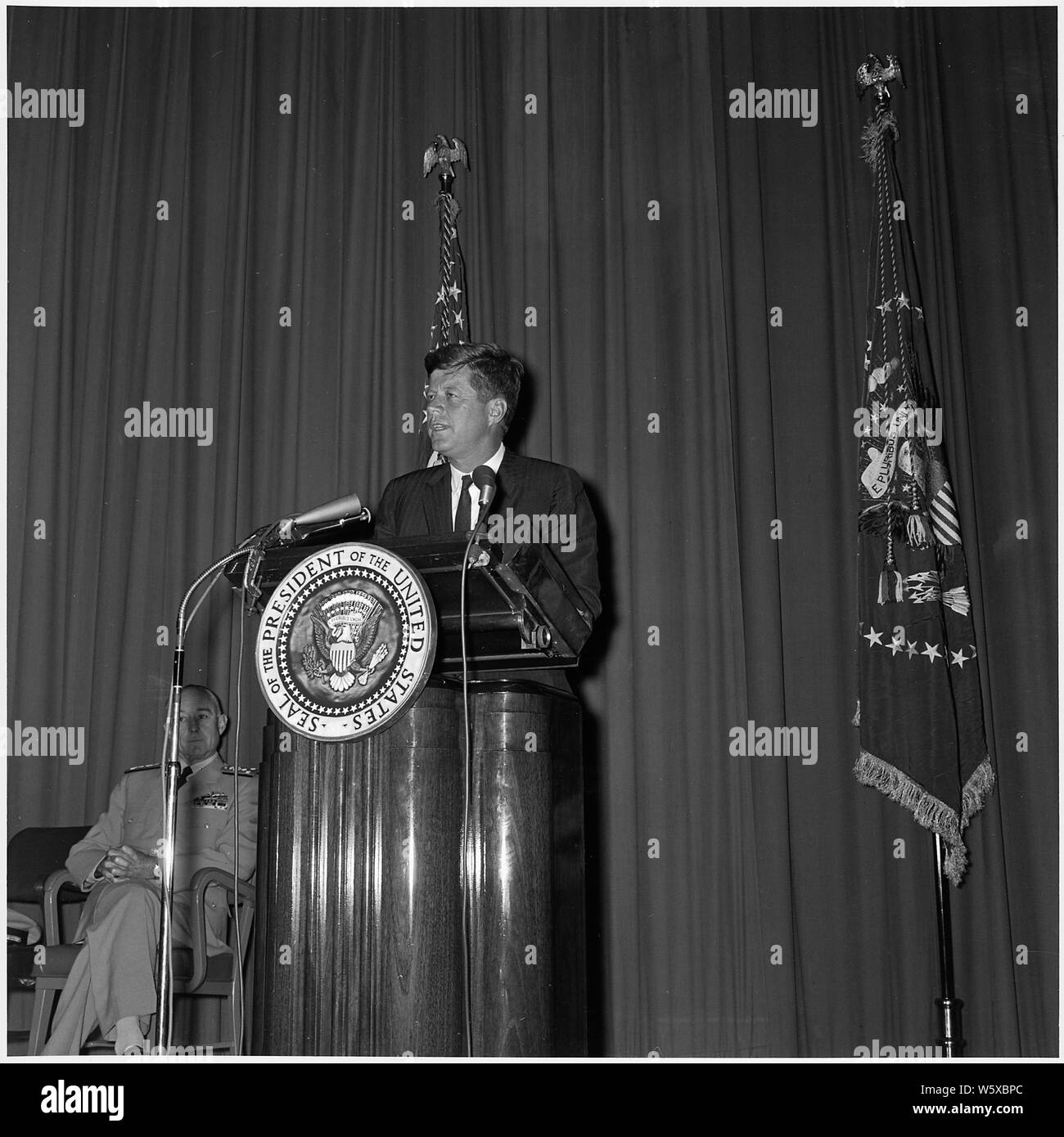 Le président annonce la nomination du nouveau directeur de la Central Intelligence Agency. Le président Kennedy à podium, Président de la Naval War College Vice amiral Bernard L. Austin. Newport, RI, Naval War College. Banque D'Images
