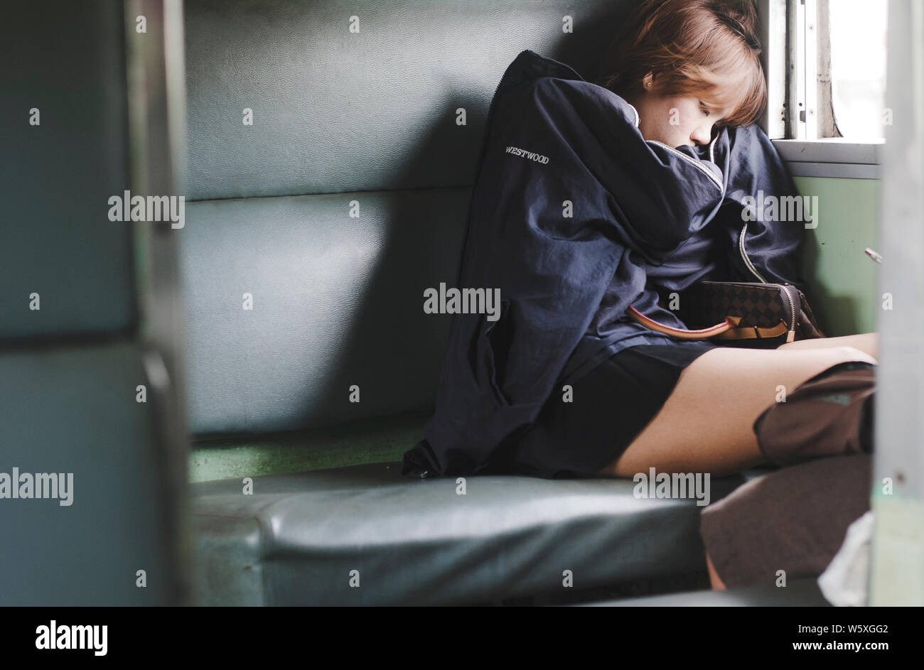 Jeune femme thaïlandais dormir paisiblement dans un train à Bangkok, Thaïlande. Banque D'Images
